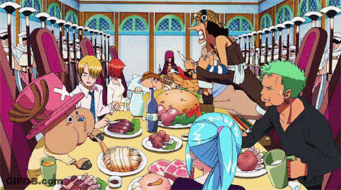 A Group Of People Sitting Around A Table With Plates Of Food GIF