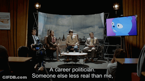 A Group Of People Sitting Around A Table With The Words " A Career Politician Someone Else Less Real Than Me " On The Bo GIF