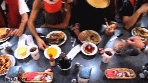 A Group Of People Sitting At A Table Eating Food GIF