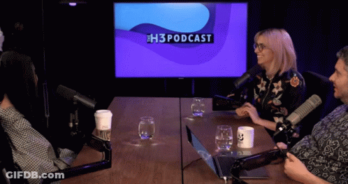 A Group Of People Sitting At A Table With Microphones And A Screen That Says H3podcast GIF