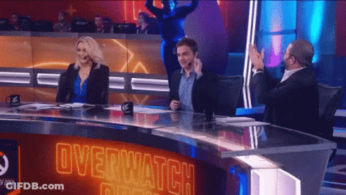 A Group Of People Sitting At A Table With Overwatch Written On The Top GIF