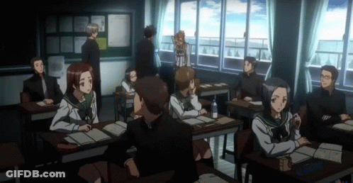 A Group Of People Sitting At Desks In A Classroom With A Bulletin Board In The Background GIF