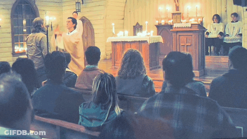 A Group Of People Sitting In A Church Watching A Priest GIF