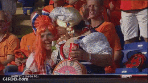 A Group Of People Sitting In A Stadium Watching A Game With A Coca Cola Can In Their Hand GIF