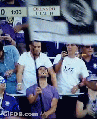 A Group Of People Sitting In A Stadium With A Sign That Says Orlando Health On It GIF