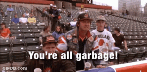 A Group Of People Sitting In A Stadium With The Words " You 'Re All Garbage " On The Screen GIF