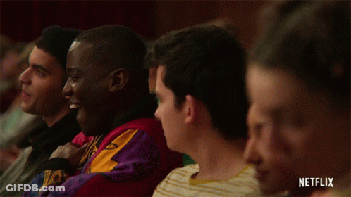 A Group Of People Sitting In A Theatre With A Netflix Logo On The Bottom GIF