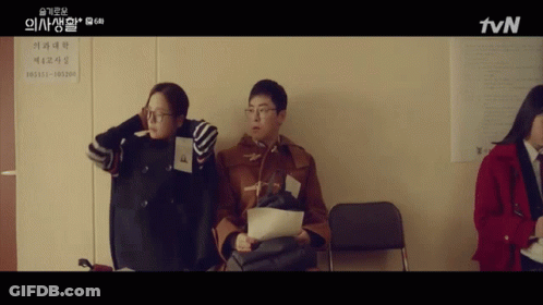 A Group Of People Sitting In Front Of A Sign That Says Tvn On It GIF
