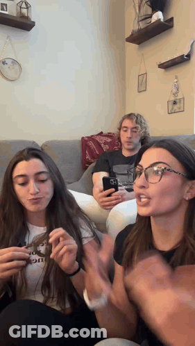 A Group Of People Sitting On A Couch One Of Whom Is Wearing A Shirt That Says " I Love You " GIF