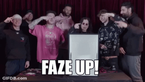 A Group Of People Standing Around A Table With A Sign That Says Faze Up In Front Of Them GIF