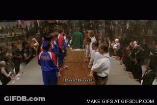 A Group Of People Standing Around A Table With The Words Das Boot Written On The Screen GIF