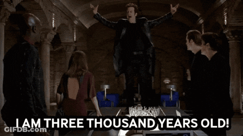 A Group Of People Standing Around A Table With The Words " I Am Three Thousand Years Old " On It GIF
