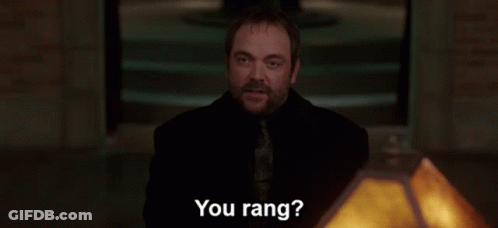 A Group Of People Standing Around A Table With The Words " You Rang " In White Letters GIF