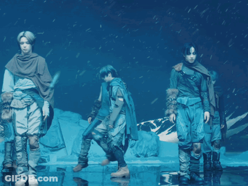 A Group Of People Standing In A Circle In Front Of A Snowy Mountain GIF