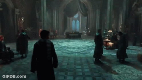 A Group Of People Standing In A Dark Room With A Circular Floor GIF