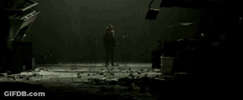 A Group Of People Standing In A Dark Room With A Red Light On Their Face GIF