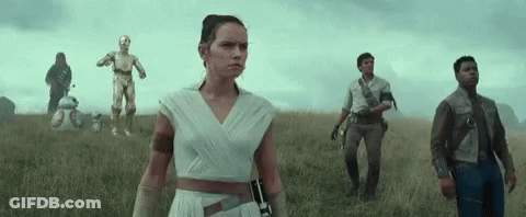 A Group Of People Standing In A Field With A C3po And Bb-8 In The Background GIF