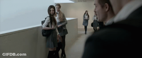 A Group Of People Standing In A Hallway With A Sign On The Wall That Says Do N't Enter GIF