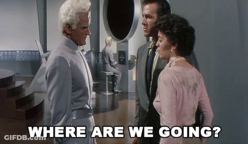 A Group Of People Standing In A Room With The Words " Where Are We Going " Above Them GIF
