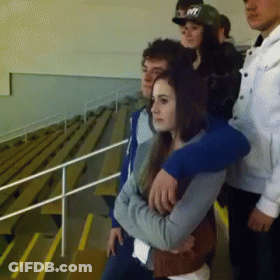 A Group Of People Standing In A Stadium With One Wearing A Hat That Says Nyc GIF