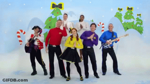 A Group Of People Standing In Front Of A Christmas Tree And Candy Canes GIF
