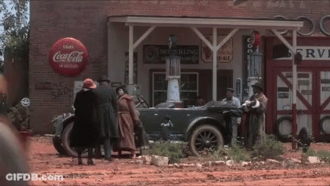 A Group Of People Standing In Front Of A Coca Cola Store GIF