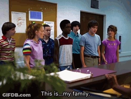 A Group Of People Standing In Front Of A Desk With The Words " This Is My Family " On The Bottom GIF
