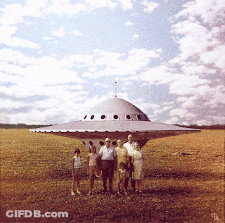 A Group Of People Standing In Front Of A Flying Saucer With The Letter R On The Bottom Right GIF
