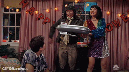 A Group Of People Standing In Front Of A Halloween Banner That Says " Happy Halloween " GIF