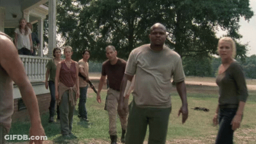 A Group Of People Standing In Front Of A House In A Field GIF