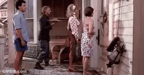 A Group Of People Standing In Front Of A House . GIF