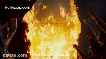 A Group Of People Standing In Front Of A Large Fire . GIF