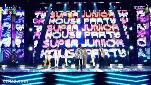 A Group Of People Standing In Front Of A Large Screen That Says " Super Junior House Party " GIF