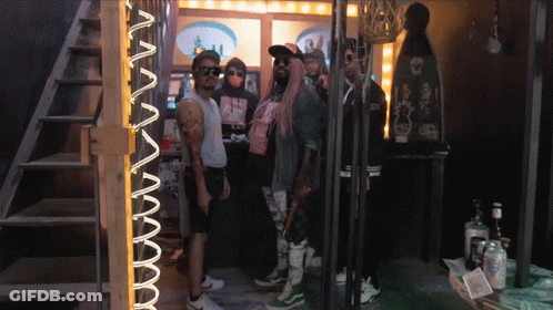 A Group Of People Standing In Front Of A Neon Sign That Says ' Aa ' GIF