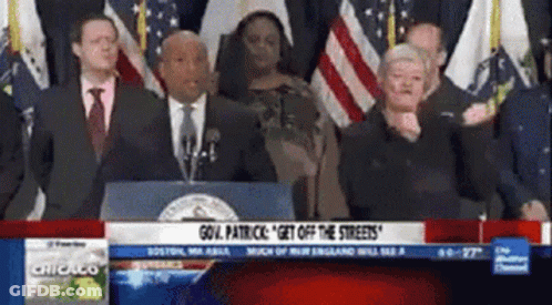 A Group Of People Standing In Front Of A Podium That Says " Gov. Patrick " On It GIF