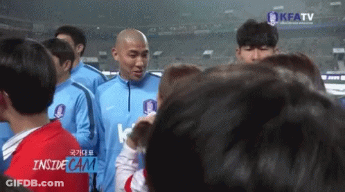 A Group Of People Standing In Front Of A Screen That Says Kfatv GIF