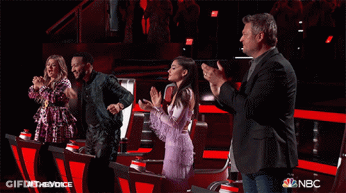 A Group Of People Standing In Front Of A Sign That Says The Voice GIF