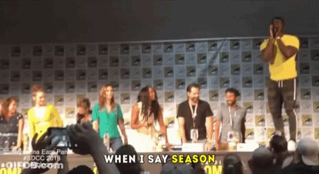 A Group Of People Standing In Front Of A Sign That Says When I Say Season On It GIF