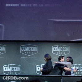 A Group Of People Standing In Front Of A Wall That Says Comic Con Paris GIF