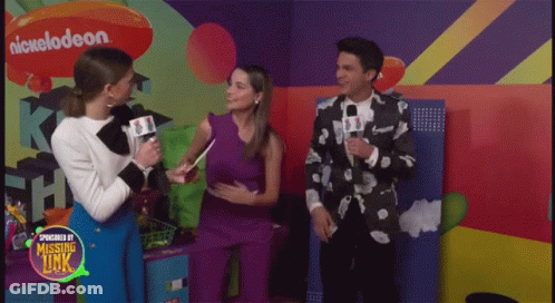A Group Of People Standing In Front Of A Wall With A Nickelodeon Logo On It GIF