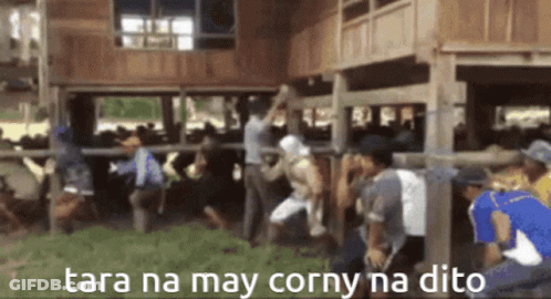 A Group Of People Standing In Front Of A Wooden Building With Tara Na May Corny Na Dito Written In The Corner GIF