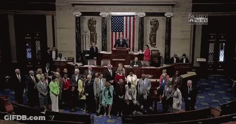 A Group Of People Standing In Front Of An American Flag With A Sign That Says Nightly Fn News GIF