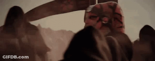 A Group Of People Standing Next To Each Other In A Dark Room With A Sword In The Background . GIF