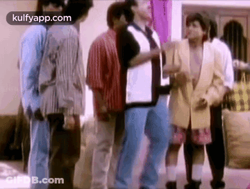 A Group Of People Standing Next To Each Other In A Living Room . GIF