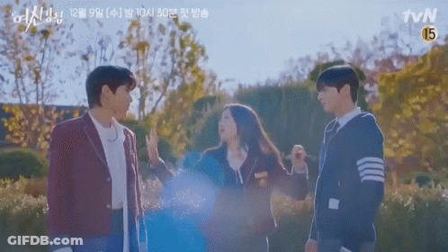 A Group Of People Standing Next To Each Other In A Park With Trees In The Background . GIF