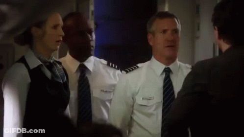 A Group Of People Standing Next To Each Other In A Room . GIF