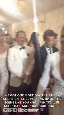 A Group Of People Standing Next To Each Other In A Room With A Caption . GIF