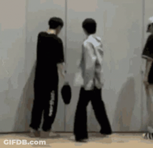 A Group Of People Standing Next To Each Other In Front Of A White Wall . GIF