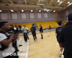 A Group Of People Standing On A Basketball Court With A Man Wearing A Black Shirt That Says ' Basketball ' On It GIF