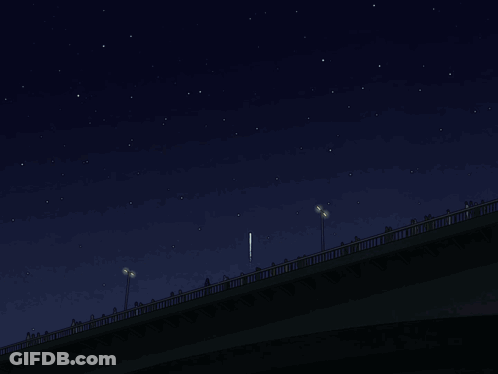 A Group Of People Standing On A Bridge Watching Fireworks GIF